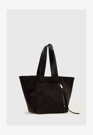 Svart semsket lær handlenett med to skulderstropper og en frontlomme med glidelås på en lys grå bakgrunn.