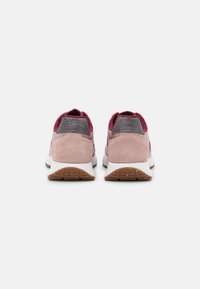 Růžové semišové a textilní tenisky s šedým akcentem na patě, bílou mezipodešví a pryžovou podešví s texturovaným vzorem.