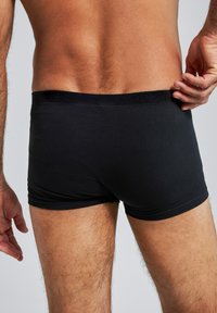Boxer shorts neri realizzati in cotone morbido, con una cintura liscia e una vestibilità aderente che mette in risalto la figura di chi li indossa.