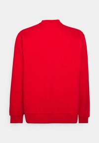 Sweatshirt rouge avec un col montant, des manches longues et des poignets et ourlet côtelés. Confectionné en tissu doux avec une texture lisse et une couleur uniforme.