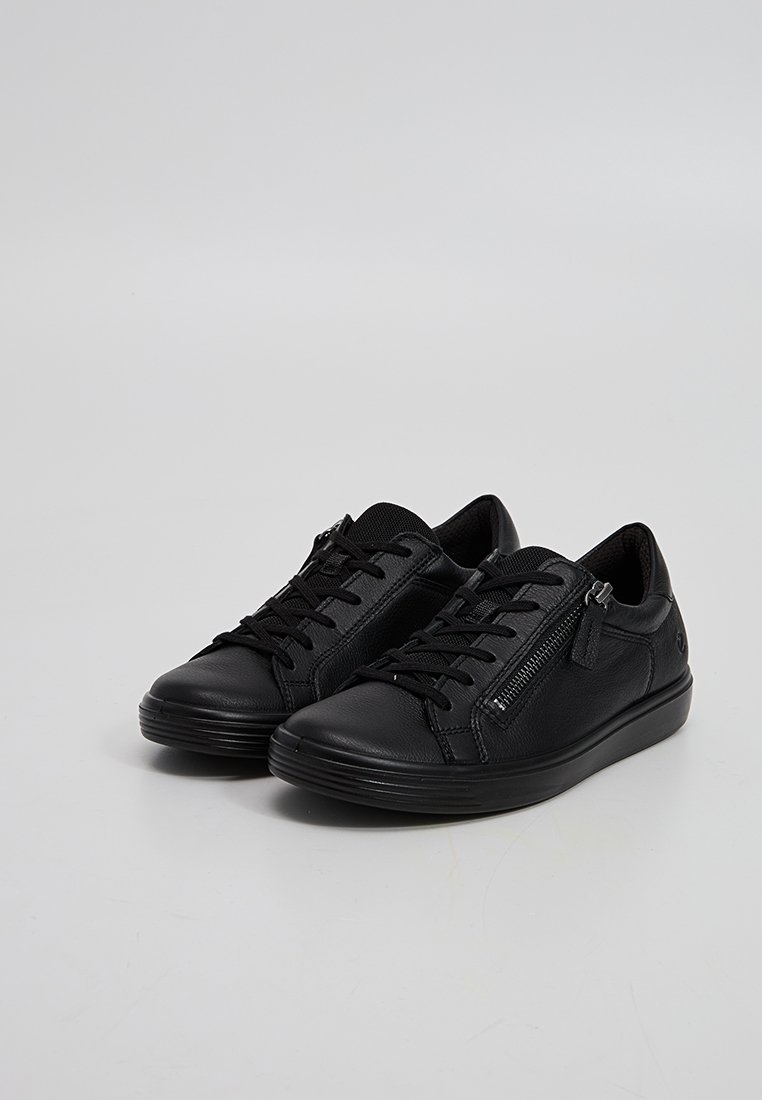 Ein Paar schwarze Ledersneaker mit Schnürsenkeln und seitlichen Reißverschlüssen auf einem schlichten hellgrauen Hintergrund.