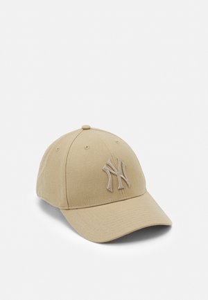 Beżowa czapka baseballowa z zakrzywionym daszkiem i wypukłym haftowanym logo "NY" na przednim panelu, lekko pochylona w prawo na białym tle.