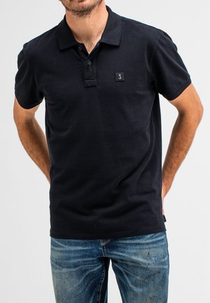 Navyblaue Baumwoll-Polohemden mit Kragen und einer Knopfleiste mit drei Knöpfen; verfügt über ein kleines Logopatch auf der Brust und kurze Ärmel.