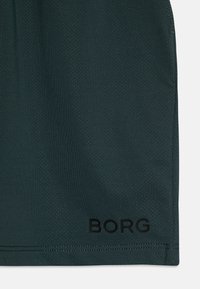 Mørkegrønne shorts med en teksturert overflate, med en svart «BORG» logo nær kanten, som understreker et enkelt og funksjonelt design.