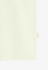 T-shirt vert clair en coton doux. Présente un ourlet droit avec une petite étiquette de marque orange sur le côté. Texture lisse.
