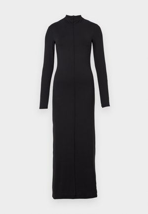 Pitkä musta mekko, joka on valmistettu sileästä kankaasta, korkealla kauluksella, pitkillä hihoilla ja keskellä vetoketju niskasta helmaan. Yksinkertainen, istuva muotoilu.