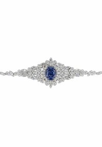 Silver bracelet adorned with an oval blue sapphire at the center, surrounded by sparkling round and marquise-cut diamonds in floral patterns.