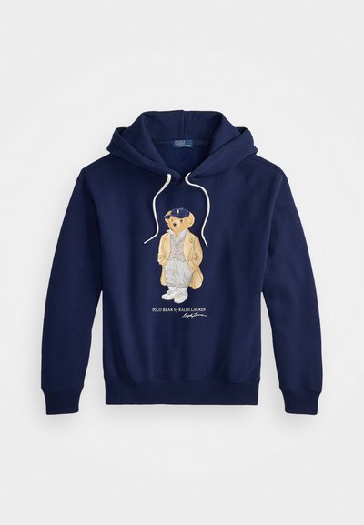 Tumesinine kapuutsiga sviiter valgete tõmblustega, mille esipinnal on stiliseeritud riietuses kaelkirjak. Kangas puuvilla segu.