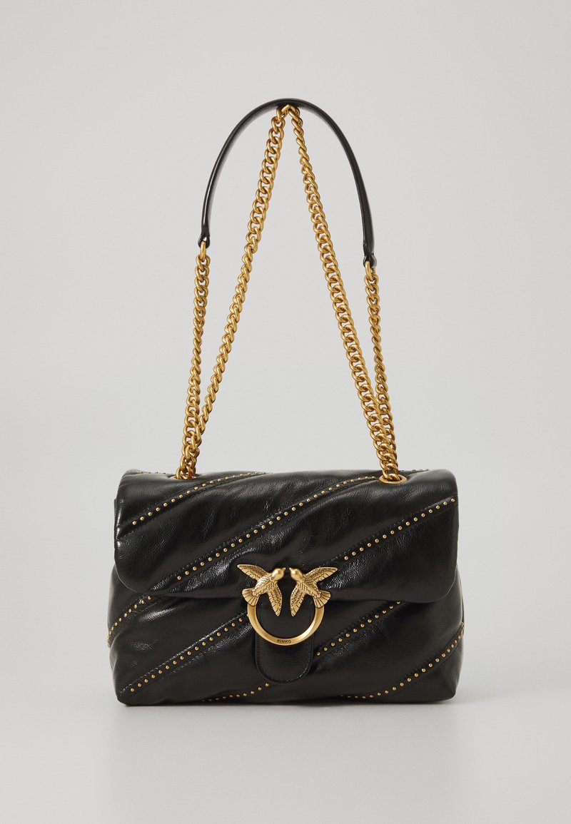 Borsa in pelle nera con borchie dorate, tracolla dorata e chiusura dorata con due figure di uccelli che si fronteggiano.