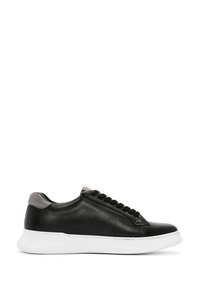 Basket en cuir noir avec une tige texturée, semelle en caoutchouc blanc et accent de talon gris. Présente une forme arrondie et des lacets contrastants.