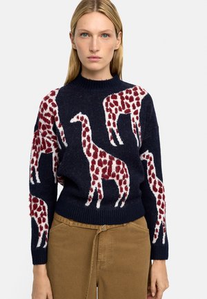 Granatowy sweter z teksturowanym wzorem żyrafy w czerwono-białe pasy. Ściągaczowy dekolt i rękawy, miękka tkanina o luźnym kroju.