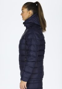 Navy blue puffer jacket with high collar, horizontal quilted design, zipper pockets, and detachable hood, featuring a smooth, glossy texture.