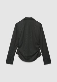 Maglietta nera a manica lunga con colletto, caratterizzata da una texture liscia e trasparente e un orlo curvo. Polsini aderenti con leggera svasatura.