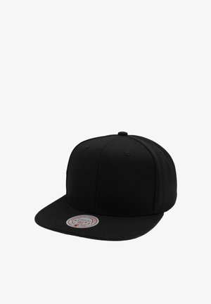 Casquette snapback noire à visière plate avec un autocollant rond argenté sur la visière indiquant les détails de la marque.