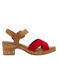 Sandalia de cuña de corcho con parte superior de imitación cuero marrón y tiras rojas cruzadas. Cuenta con una correa para el tobillo ajustable y un tacón texturizado.