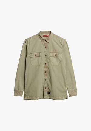 Camisa de manga larga verde oliva claro hecha de algodón. Cuenta con un collar, cierre frontal de botones y dos bolsillos en el pecho con solapa y detalles de botones.