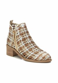 Stivaletto intrecciato con fili metallici dorati, argentati e bronzati. Presenta un tacco basso a blocco e una zip laterale. Il design aperto ne migliora la traspirabilità.