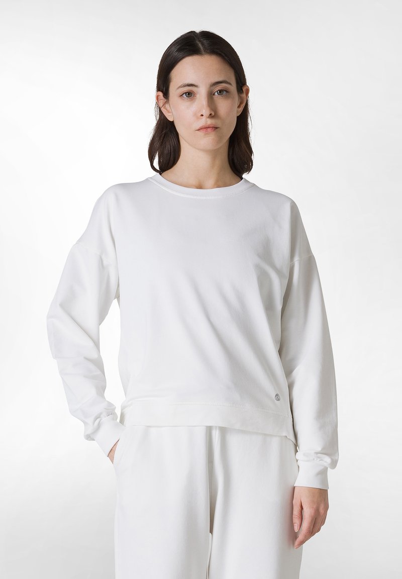 Vit sweatshirt med långa ärmar, rundad halsringning och en avslappnad passform. Tillverkad av mjukt tyg, med minimal design och logotypdetalj.