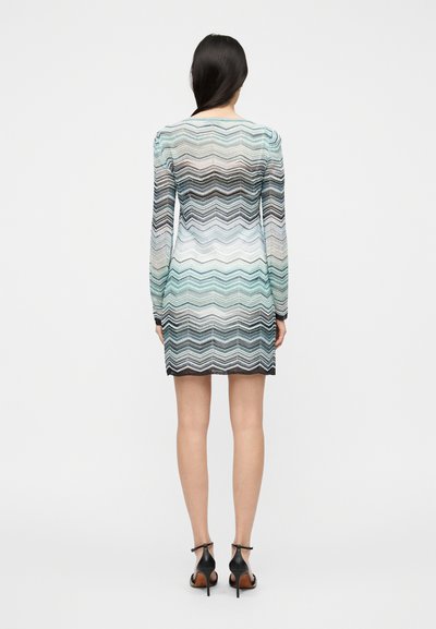 Φόρεμα με μακριά μανίκια και ζιγκ ζαγκ μοτίβο σε αποχρώσεις μπλε, λευκού και μαύρου, με εφαρμοστή σιλουέτα και κοντή γραμμή.
