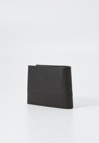 Svart skinnlommebok med en teksturert overflate og glatt bunnpanel, med et slankt design og en fold-over topp.