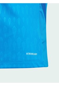 Kortärmad blå träningsskjorta med ett diamantmönster, tillverkad av ett andningsbart tyg, med "AEROREADY" tryckt på fållen.