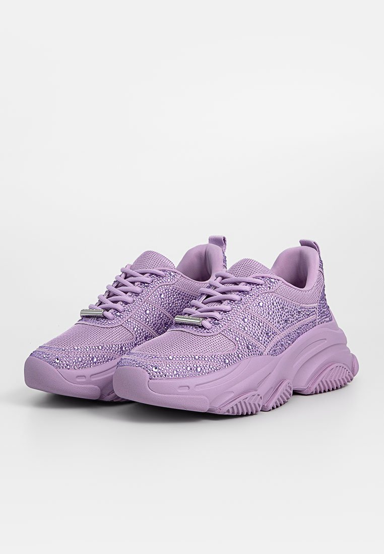 Lila Sneakers aus Textil mit einer strukturierten Oberfläche. Besitzen eine gepolsterte Sohle, eine Schnürung und funkende Akzente im Obermaterial.