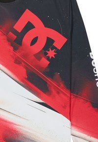 Black and red long-sleeve shirt featuring a large white and red DC logo, abstract graphic design, and textured, breathable fabric.