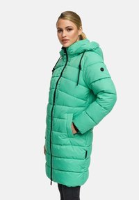 Light green puffer coat with a hood, featuring a zip closure, pockets, and black accents on the zipper and drawstrings. Textured quilted design.