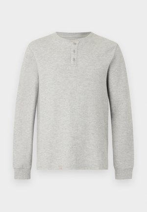 helehall hall pikkade varrukatega termokleit ümara kaelusega ja kolme nupuga läbilõikega, soonikkoes varrukate ja tekstuurse kudumi kangaga.