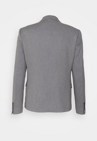 Veste de costume gris ajustée avec revers crantés, manches longues et deux boutons aux poignets. Tissu lisse et texturé avec une coupe structurée.