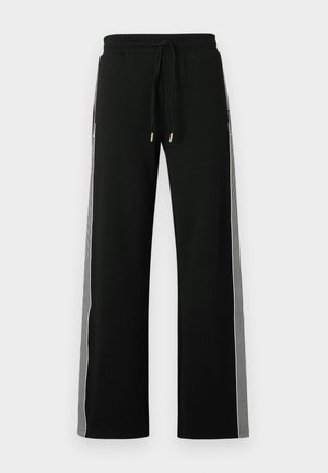 Pantalones jogger anchos negros con cintura elástica y cordón. Presentan paneles laterales a rayas en contraste y detalles de herrajes en tono dorado.