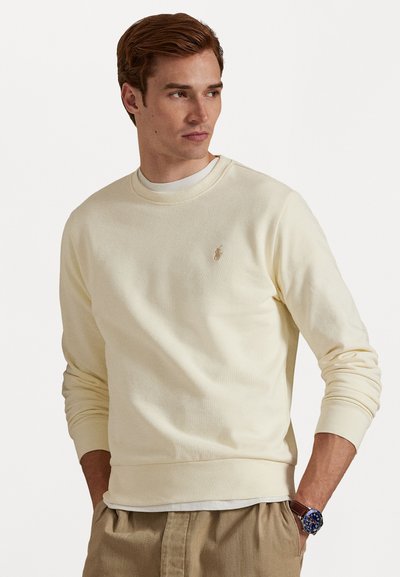 Hellgelbes Crewneck-Sweatshirt aus weichem Material mit einem kleinen gestickten Logo auf der Brust sowie gerippten Bündchen und Saum.