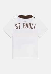 Fehér póló barna gallérral, a hátulján barna színű "ST. PAULI" és "1910" felirattal. Rövid ujjú, sima textúrájú.