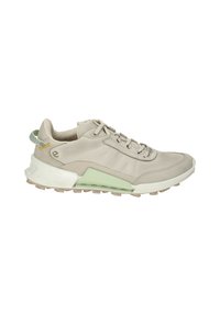 Beige athletic shoe with a textured upper, green accent on the sole, and a pull tab at the heel. Features a lace-up design and rubber outsole.