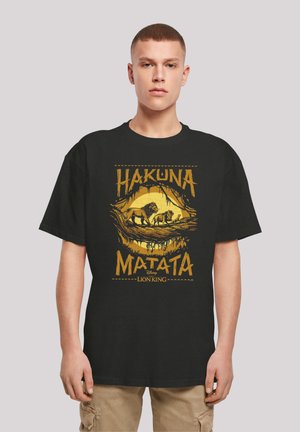 Black cotton t-shirt featuring a yellow graphic with "Hakuna Matata" text and lion imagery from Disney's The Lion King. Short sleeves, relaxed fit.