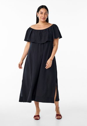 Abito maxi nero off-shoulder con dettagli a volant a strati, spacchi laterali e una silhouette fluida realizzata in tessuto leggero.