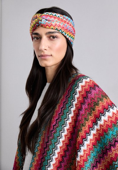 Mehrfarbiger Zickzack-Muster-Stirnband mit einem verdrehten Design. Tragen Sie es mit einem bunten, gemusterten Schal, der lebendige Streifen und Texturen aufweist.