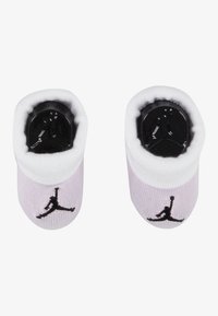 helelillad puuvillased beebisussid musta kummist taldse, valge äärise ja musta Air Jordani logoga; ümar kuju ja pehme tekstuur.