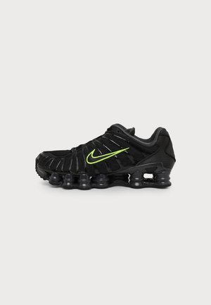 Черно бягащо обувка Nike с ярко зелено лого swoosh и видима въздушна възглавница на подметката, показана отстрани на обикновен фон.