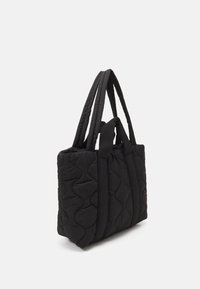 Czarna pikowana torba tote z fakturowanymi falami, podwójnymi paskami z materiału i prostokątnym kształtem. Kompaktowy design, odpowiedni do codziennego użytku.