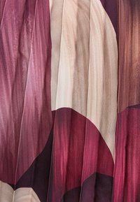 Jedwabna tkanina z abstrakcyjnym wzorem dużych kół w odcieniach bordo, różu i taupe, o gładkiej fakturze i subtelnym połysku.