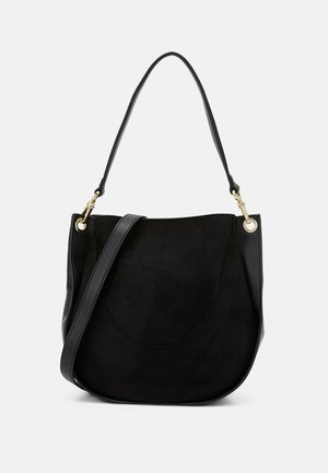 Sac à main en daim noir avec détails en cuir. Forme arrondie, bandoulière unique et ferrures dorées. Texture lisse.