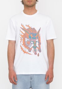 Weißes Baumwoll-T-Shirt mit einem bunten Grafikdesign, das Flammen und ein mythisches Wesen in orange und türkisfarbigen Tönen zeigt.