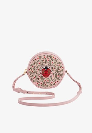 Pyöreä vaaleanpunainen olkalaukku punotulla hihnalla, jossa on kirjailtu punainen leppäkerttu, jota ympäröivät vihreät lehdet ja pienet punaiset sydämet.