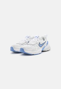 Weiße Sportschuhe mit Obermaterial aus Mesh, blauen Akzenten und gepolsterter Zunge. Merkmale sind eine strukturierte Sohle und ein auffälliges Nike-Logo an den Seiten.