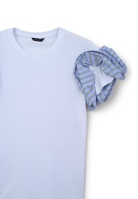 T-shirt bianco con un dettaglio in tessuto a righe blu e bianche sulla spalla sinistra, caratterizzato da una texture ondulata e un design drappeggiato.