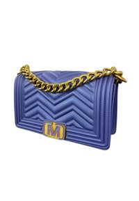 Borsa a tracolla trapuntata viola con motivo a zigzag, tracolla in catena dorata e placca con logo dorato. Materiale sintetico testurizzato, forma rettangolare.
