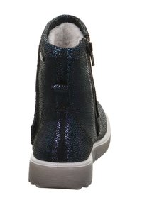 Blau-schwarzer Knöchelstiefel aus strukturiertem Stoff mit glänzendem Punktmuster, ausgestattet mit einem seitlichen Reißverschluss und einer grauen Gummisohle mit Profil.