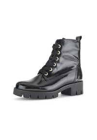 Bottines en cuir verni noir avec un bout arrondi, un laçage à l'avant, des œillets dorés et une semelle plateforme épaisse noire.