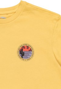 Gelbes Baumwoll-T-Shirt mit einem kreisförmigen Grafikdesign, das einen Kaktus, einen Sonnenuntergang und eine geschichtete Landschaft in lila, rot und grauen Farbtönen zeigt.